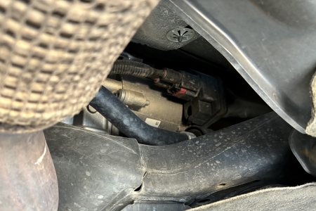 The black box pictured is the electronic steering control module, where a technician checks for proper power and ground connections during diagnostics.