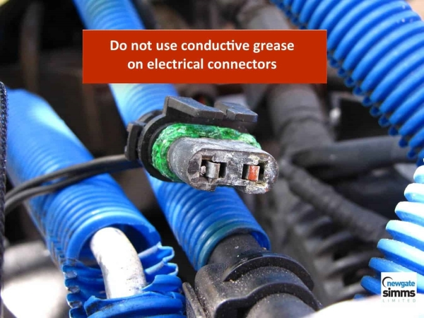 Automotive connector overfilled with dielectric grease causing pin contact and communication problems.