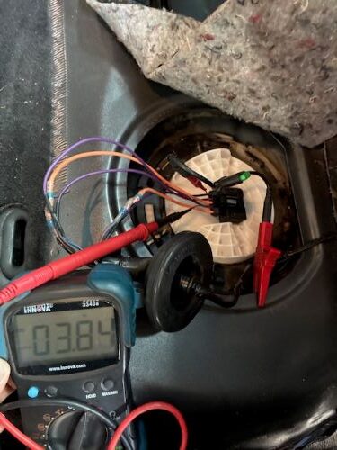 Auto Electrical testing showing Signal return grounded - Auto Repair San Antonio | Auto Service Experts Fuel tank access panel open with test leads connected while diagnosing the fuel level signal return circuit.