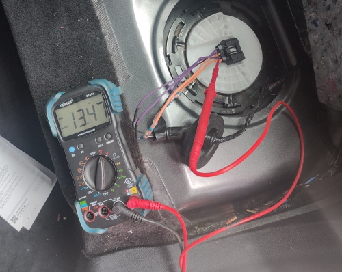 Voltage check at fuel tank connector during diagnostic for fuel signal issues - Auto Repair San Antonio | Auto Service Experts Multimeter reading 13.47 volts during a voltage check at the fuel tank connector while diagnosing fuel level signal issues.