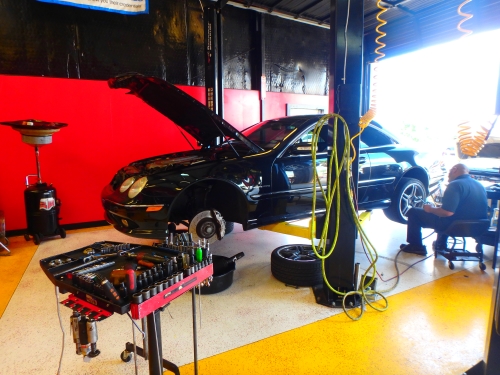 Brake job on Mercedes at Auto Service Experts San Antonio shop - Auto Repair San Antonio | Auto Service Experts ASE-certified mechanic diagnosing squeaking noise when braking on a car at Auto Service Experts in San Antonio