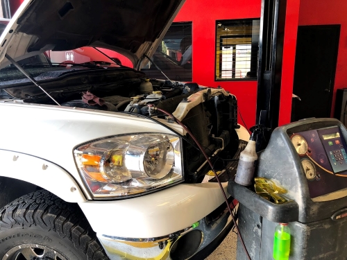 Auto AC refrigerant pressure testing on 07 Dodge Ram 1500 57 - Auto Repair San Antonio | Auto Service Experts ASE technician performing auto AC refrigerant pressure testing on a Dodge Ram 1500 in San Antonio