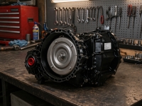 ford-edge-fn4a-el-transmission-side-view – Auto Repair San Antonio | Auto Service Experts Ford Escape 6F35 transmission sitting on a clean workbench at Auto Service Experts in San Antonio, with Carlos Rodriguez, Master Technician, inspecting the bell housing and torque converter area during diagnosis